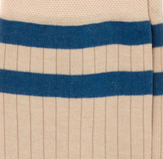 Dettaglio dei calzini "Atletico" a coste color panna da uomo. Con due fasce orizzontali blu e profilo blu.