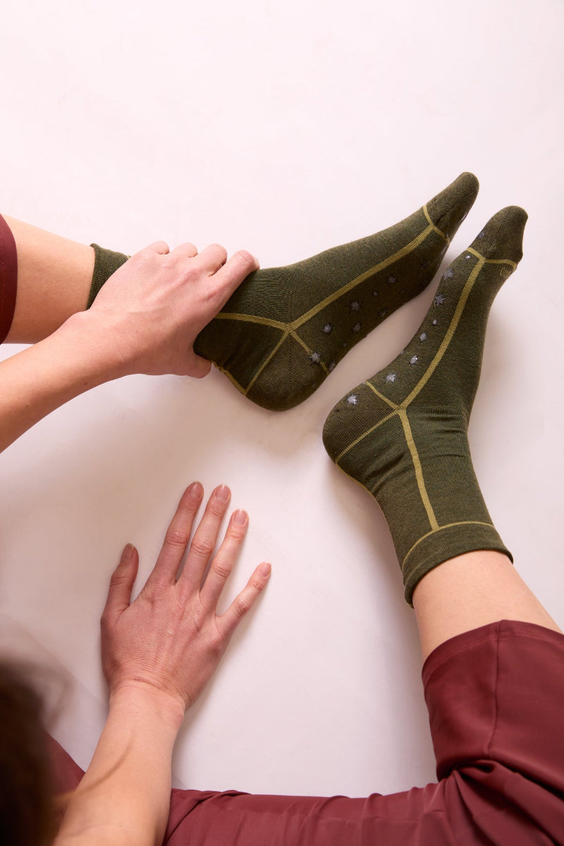 Calze antiscivolo verde oliva per pilates da donna di Arturo Stories. Con gommini a forma di stelle sulla pianta e profilo verde chiaro.