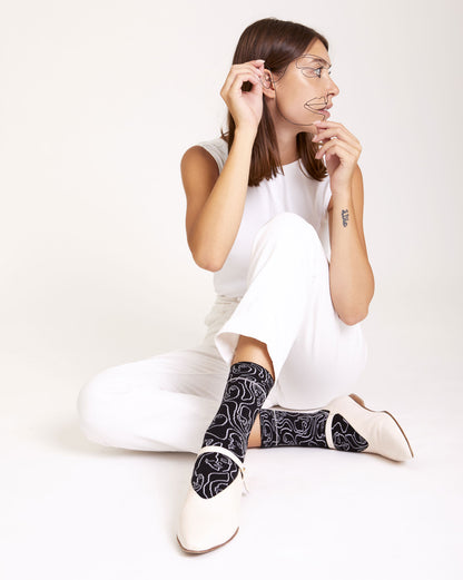 Calze "Di contorno" con facce ricamate in bianco e nero di Arturo Stories.