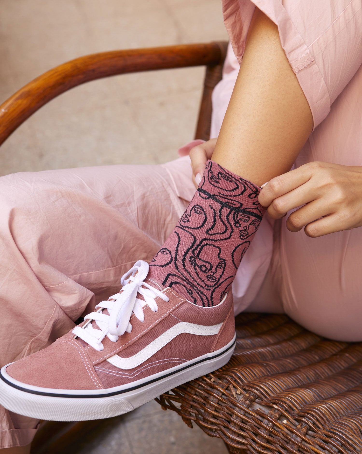 Calze "Di contorno" rosa con facce ricamate nere di Arturo Stories.