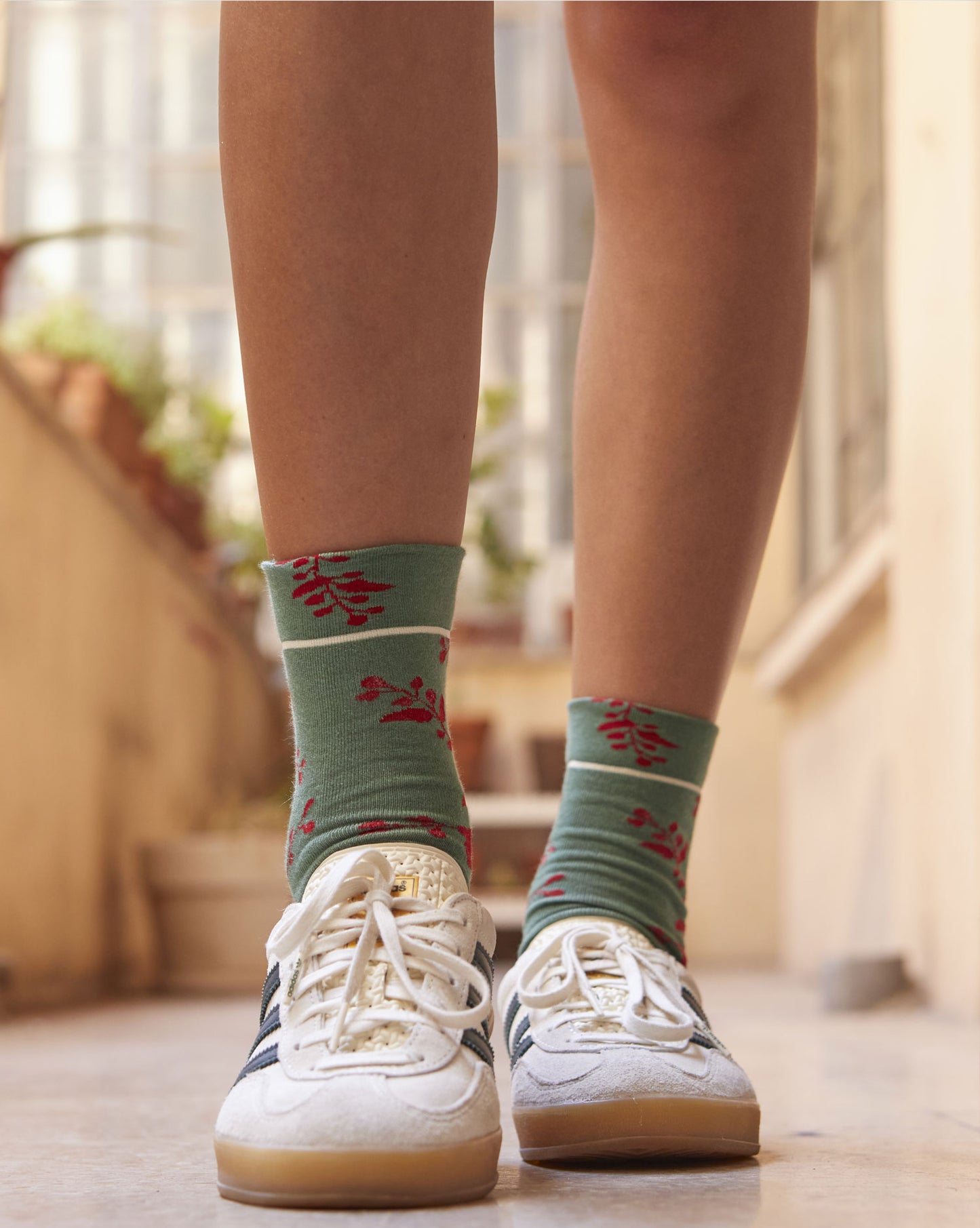 Calze indossate di Arturo Stories con fondo verde e fantasia floreale rossa da donna.