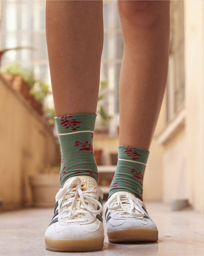 Calze indossate di Arturo Stories con fondo verde e fantasia floreale rossa da donna.