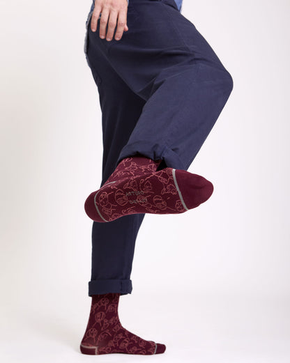 Calze con fantasia cani e gatti color bordeaux, lunghi da uomo di Arturo Stories indossate.