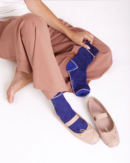 Calze indossate "In volo" ricamati con uccellini blu da donna di Arturo Stories.