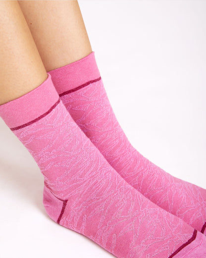 Calze indossate "In volo" ricamati con uccellini rosa da donna di Arturo Stories.