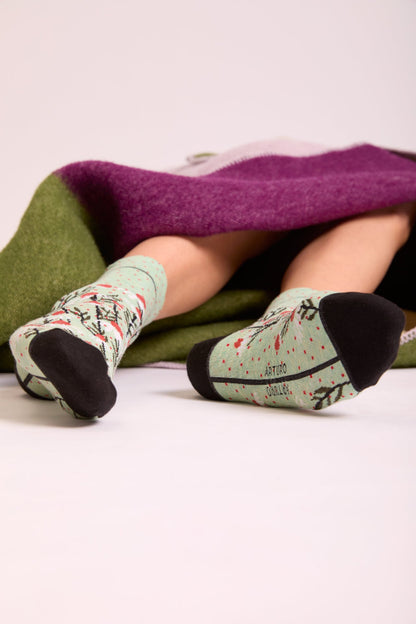 Calze con margherite verde menta da donna di Arturo Stories. Con fiori bianchi, punta e tallone neri e profilo nero lungo il retro della gamba.