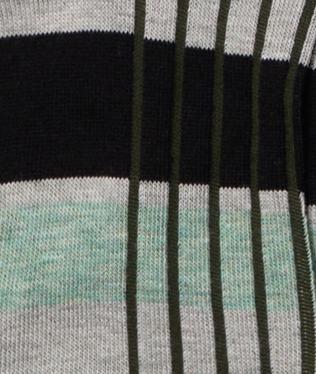 Dettaglio macro delle calze "Organetto" verde menta di Arturo Stories da uomo indossate. A righe, con dettagli verde oliva, grigi, mattone.