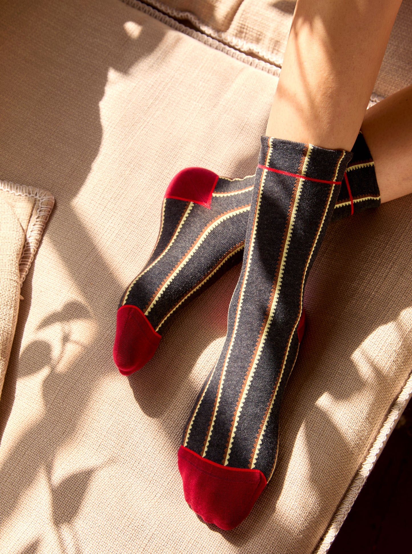 Calze a righe smerlate antracite da donna di Arturo Stories. Righe verticali bicolor, punta, tallone e profilo rossi. Indossate.