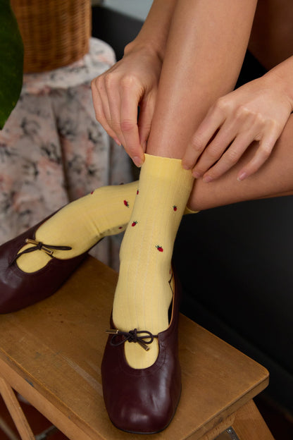 Calzini a costine gialli indossati da donna di Arturo Stories. Con fantasia a fragole rosse ricamate.
