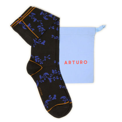 Calzini lunghi a fiori da donna di Arturo Stories, con fondo nero con fantasia floreale blu e profilo senape.
