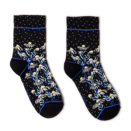 Calzini con margherite neri da donna di Arturo Stories. Con fiori bianchi, punta e tallone neri e profilo blu lungo il retro della gamba.