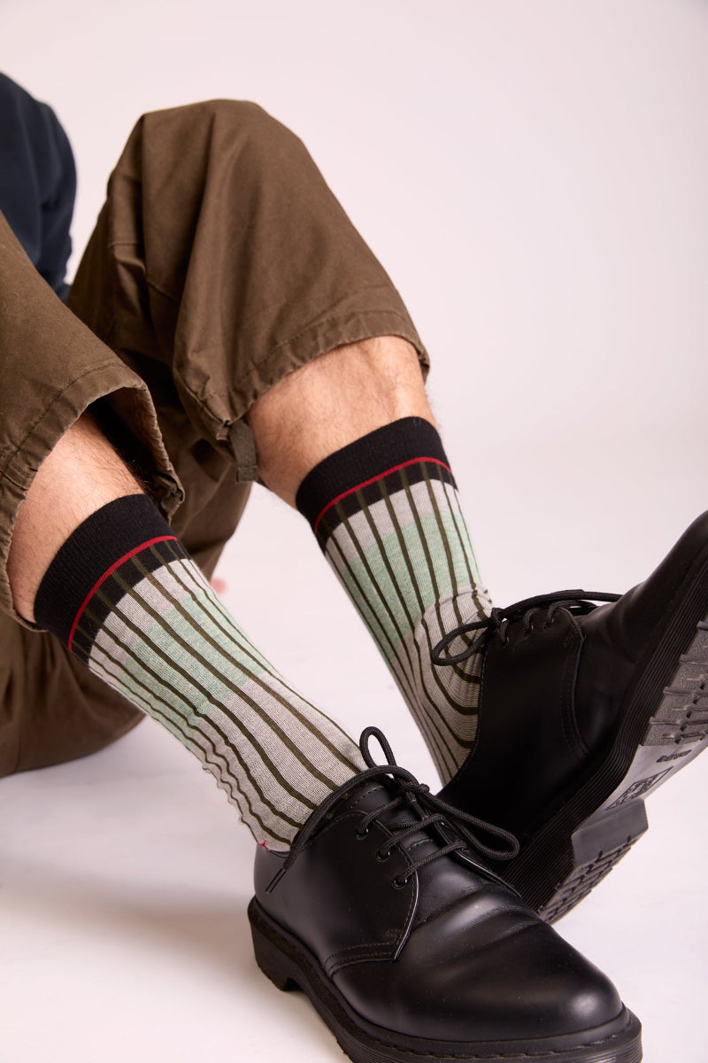 Dettaglio dei calzini "Organetto" verde menta indossati di Arturo Stories. Da uomo, a righe verde oliva, grigio, mattone.