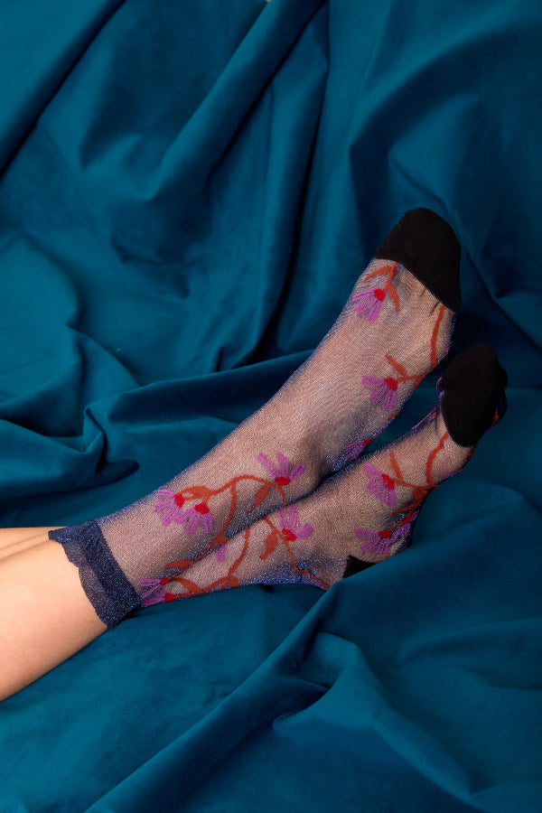 Calzini trasparenti blu notte da donna di Arturo Stories indossati. Con fiori ricamati.