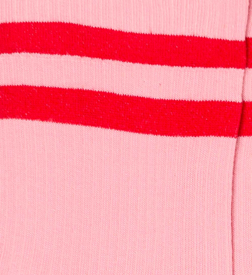 Dettaglio dei calzini "Atletico" a coste rosa da donna di Arturo Stories. Con due fasce orizzontali rosse e profilo marrone sul retro.