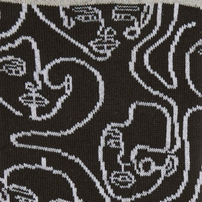 Dettagli dei calzini "Di contorno" con facce ricamate in bianco e nero di Arturo Stories.