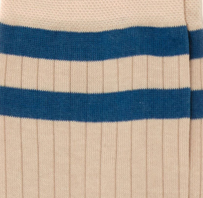 Dettaglio dei calzini "Atletico" a coste color panna da uomo. Con due fasce orizzontali blu e profilo blu.   