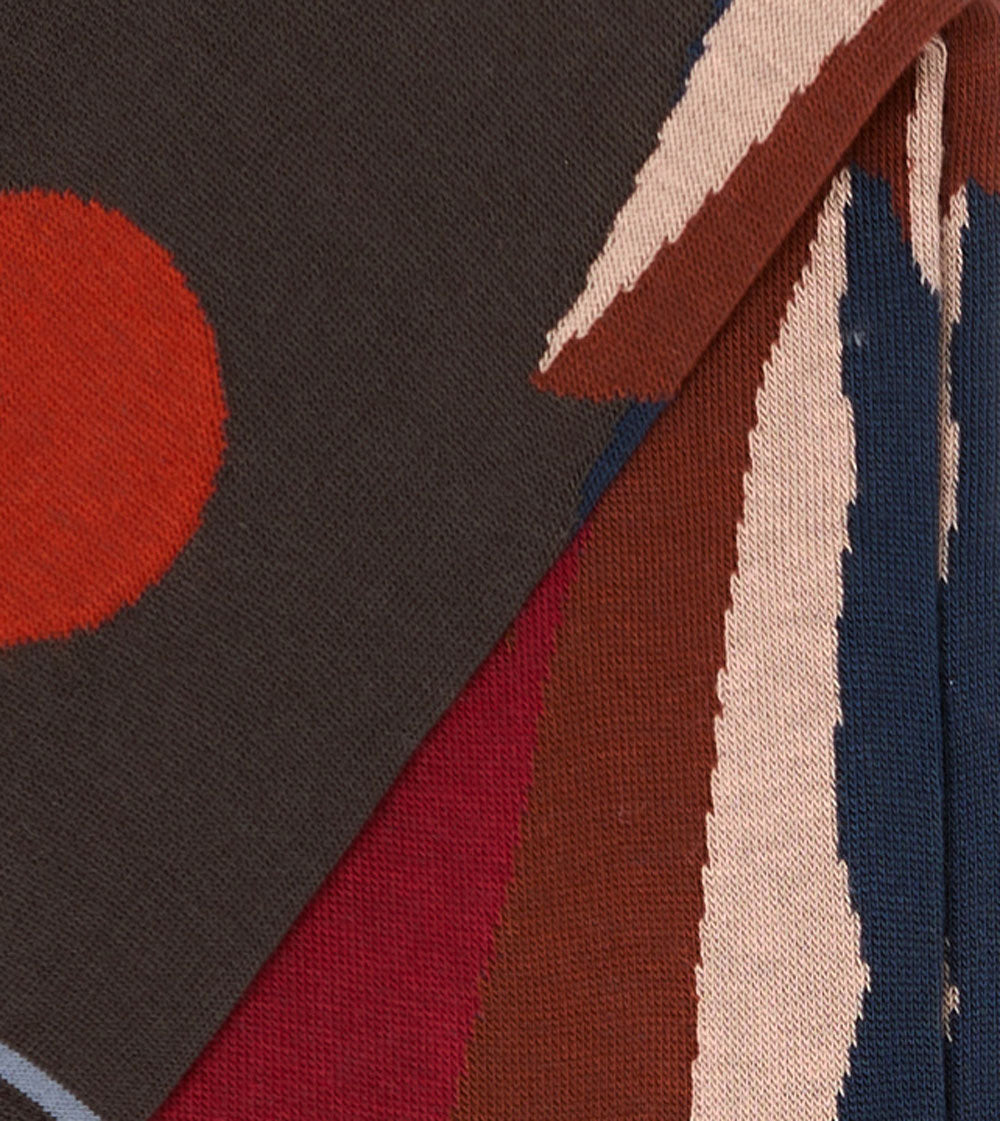 Dettaglio calzini "Svetta in alto" lunghi da uomo di Arturo Stories. Montagne e sole ricamati su fondo antracite.